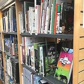 Böcker på en hylla i ett bibliotek.