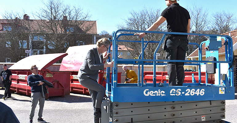 Skolministern klättrar upp i liften.
